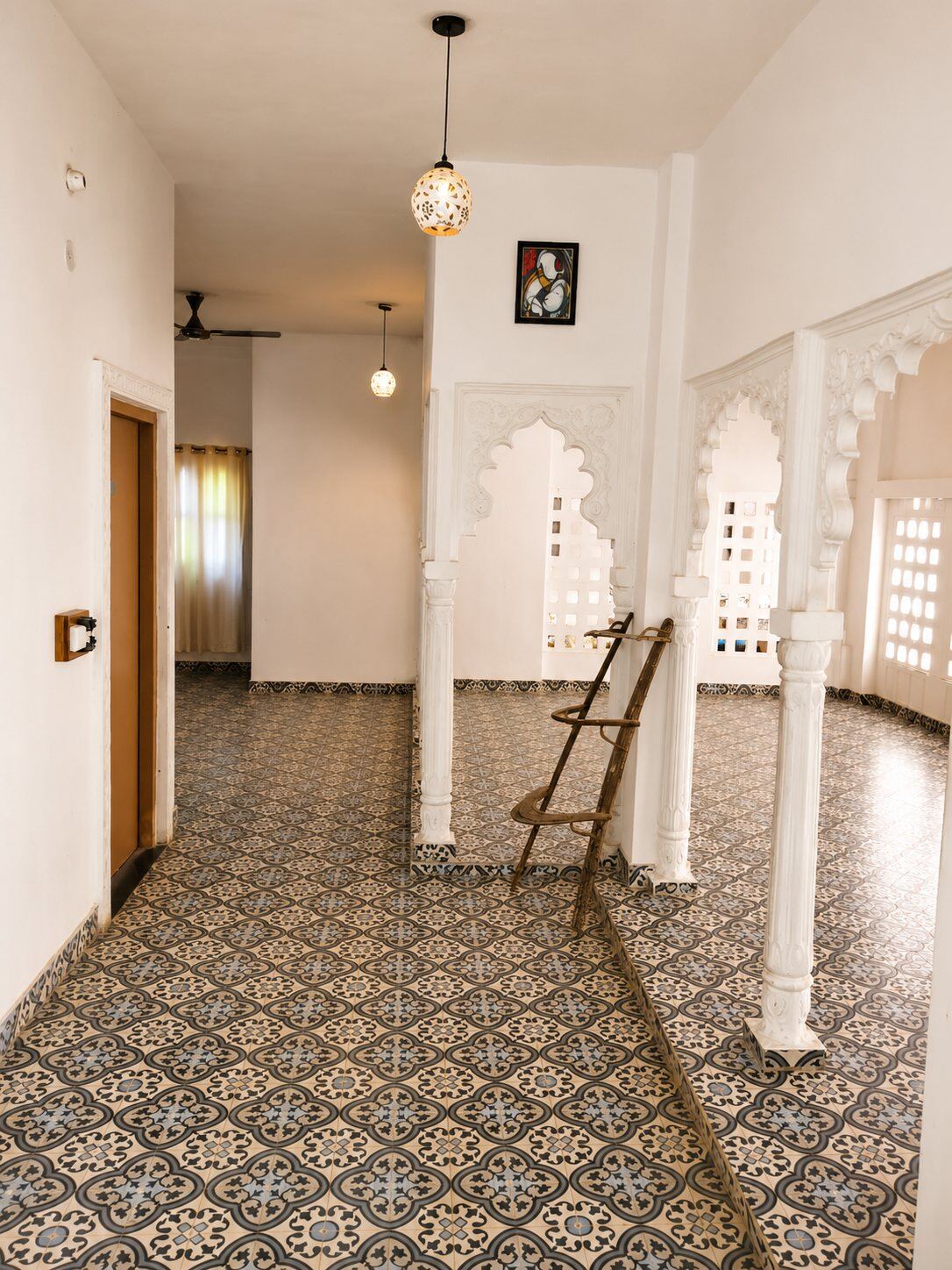Sunlit tiled hallway with white arches